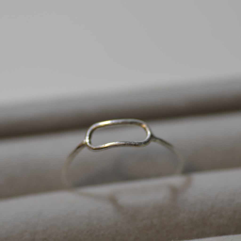 Silver ring on a textured beige surface