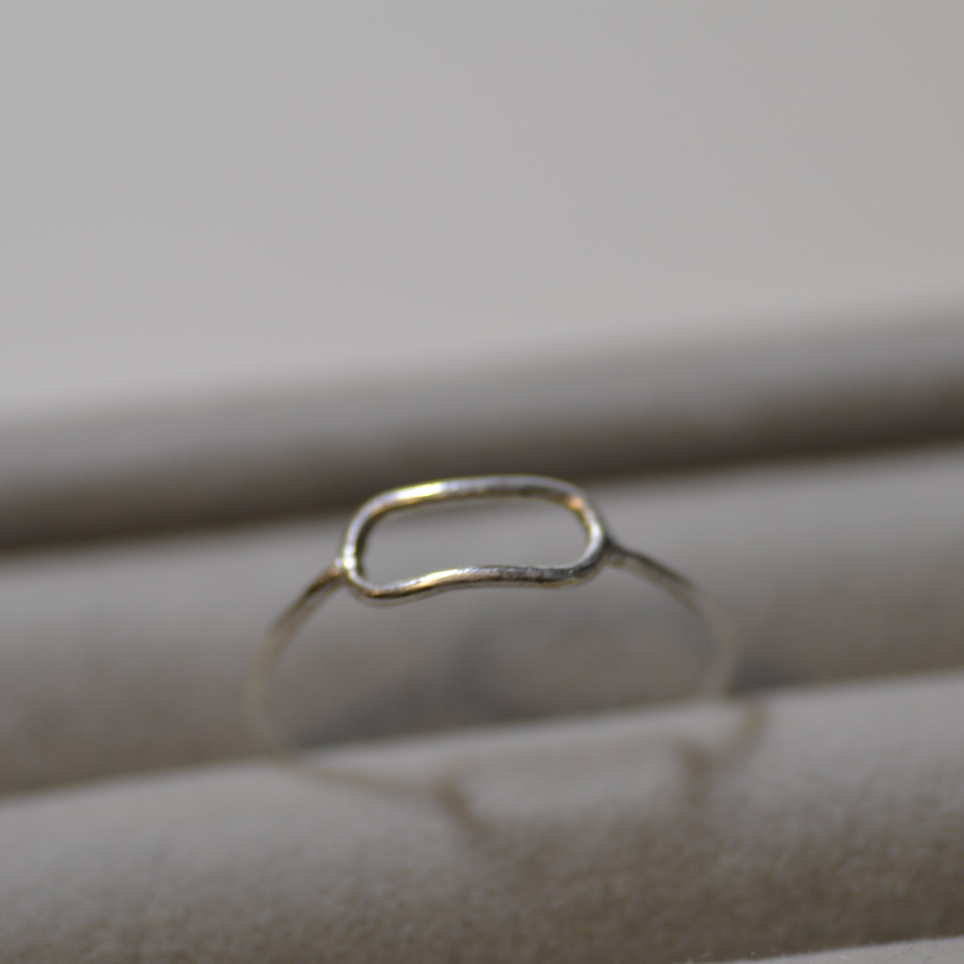Silver ring on a textured beige surface