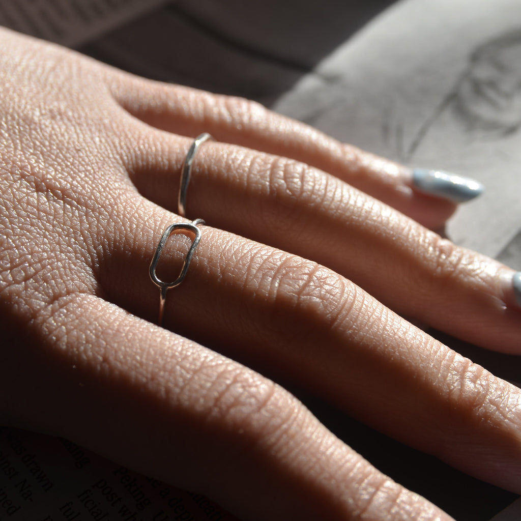Close-up of a hand with silver rings on a blurred background