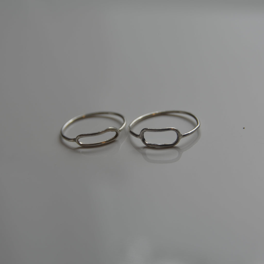 Two silver rings on a gray background