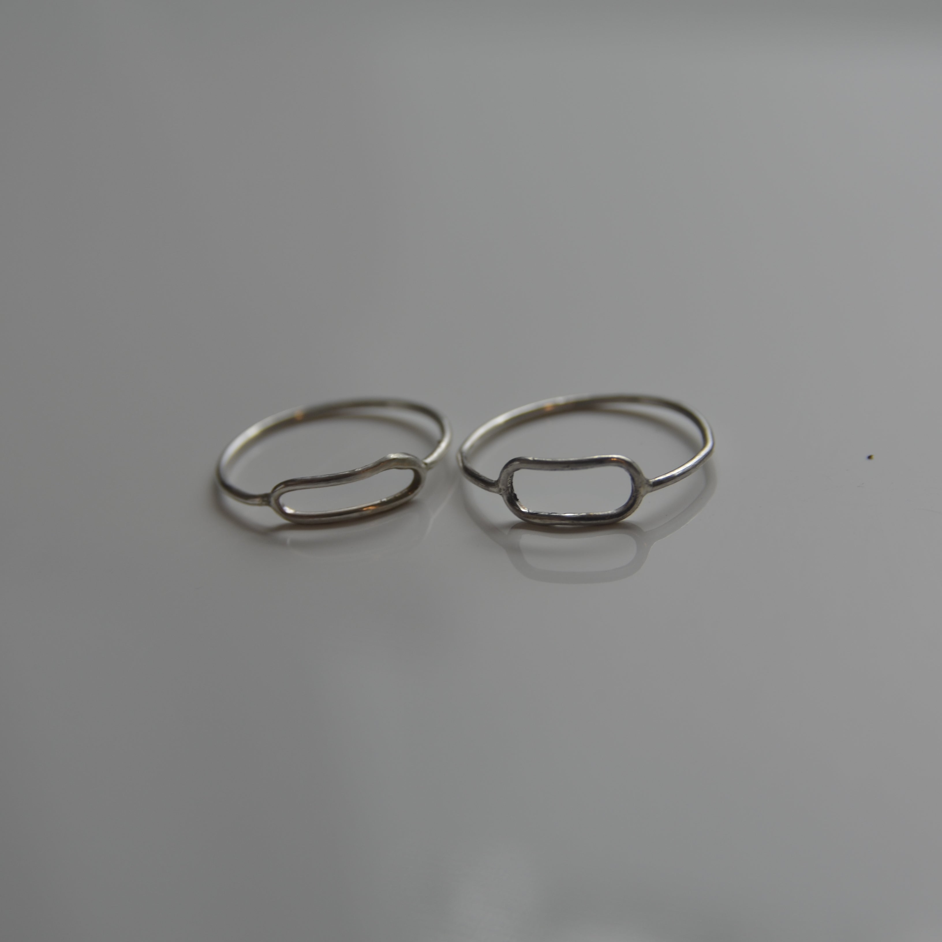 Two silver rings on a gray background