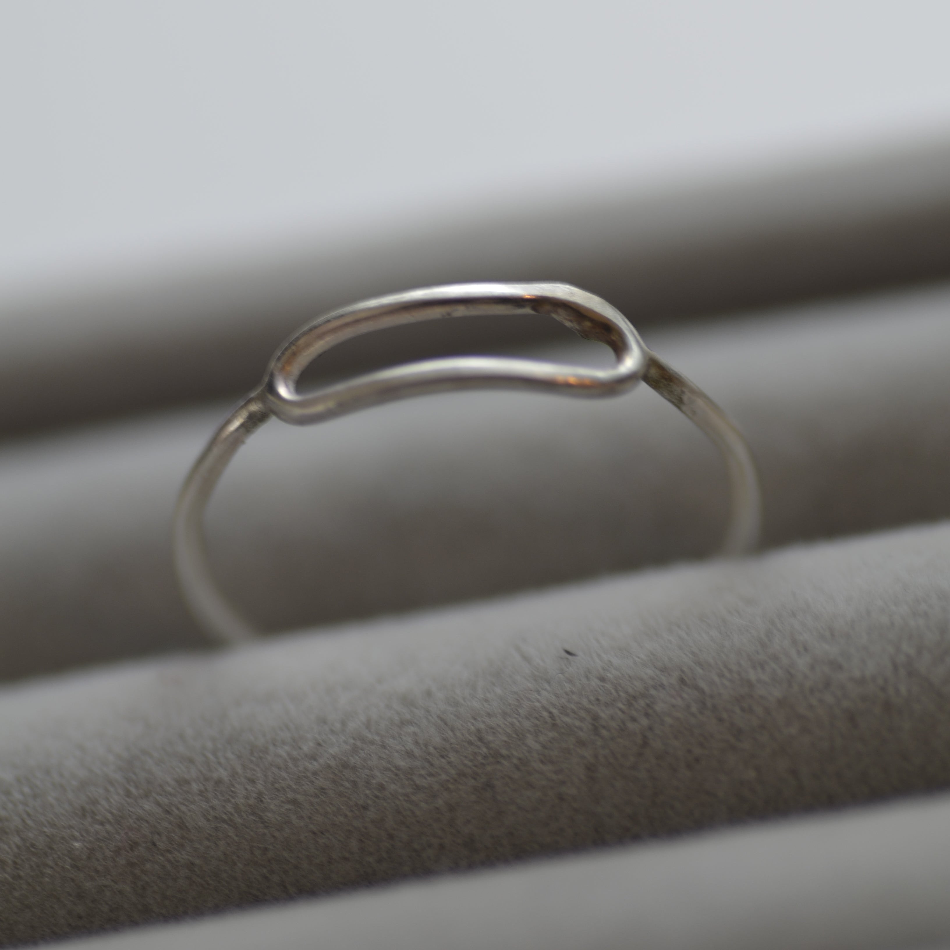 Close-up of a silver earring on a neutral background