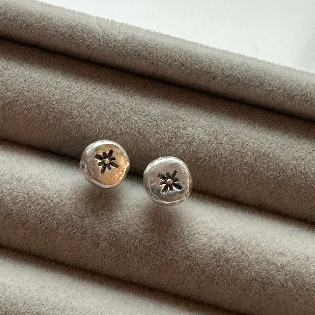 Silver earrings on a textured gray surface